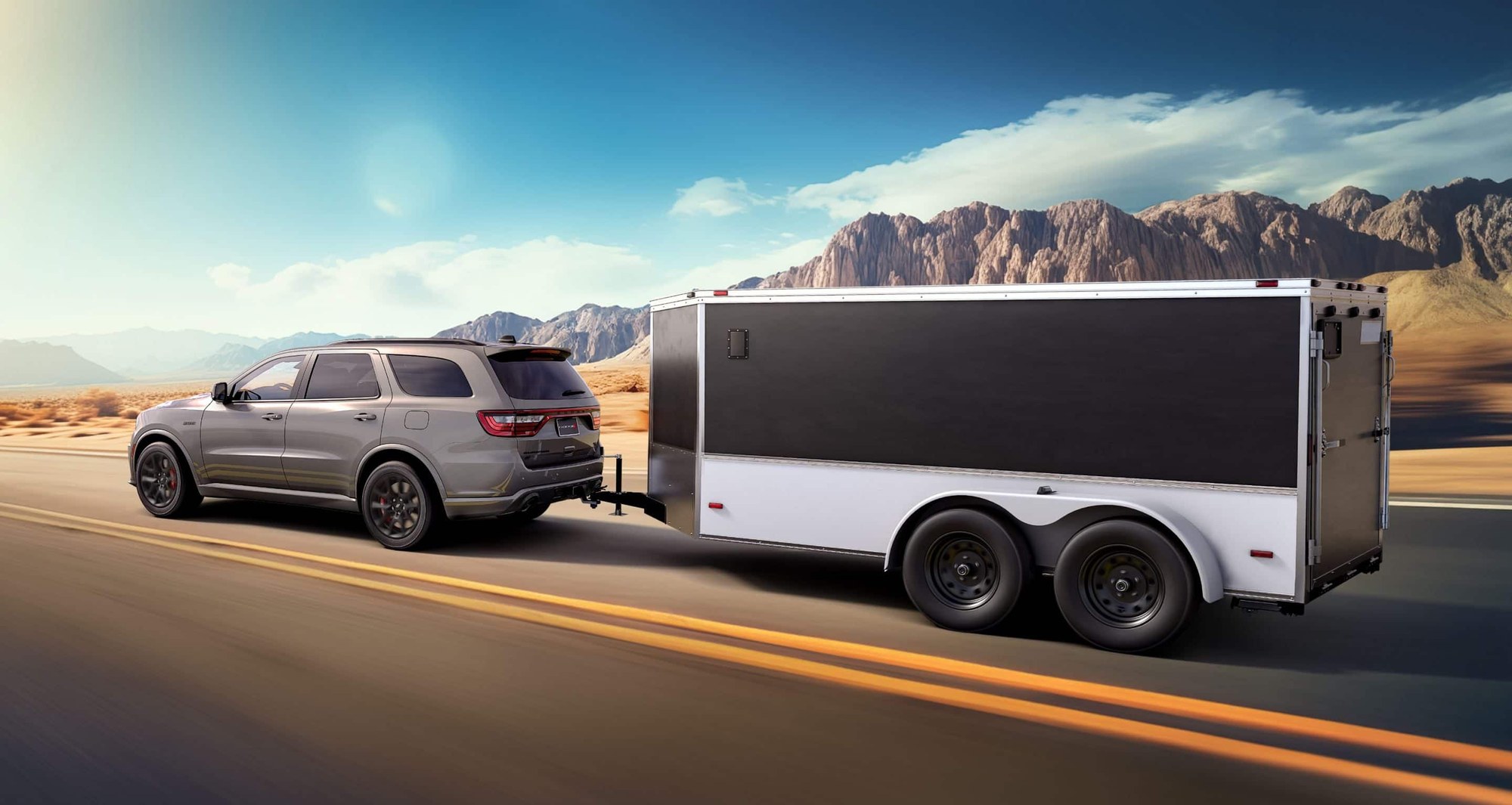 Gray 2026 Dodge Durango R/T 392 towing a large box trailer on a highway