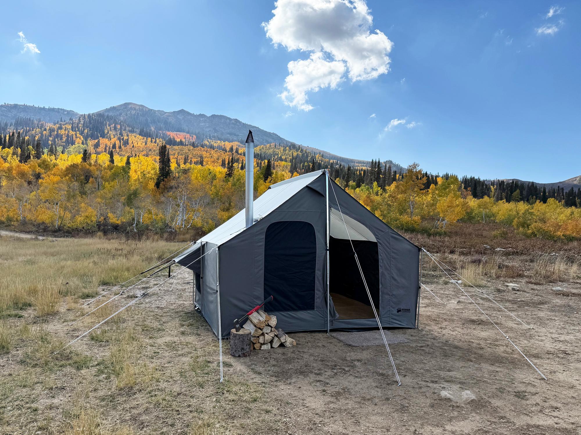 Kodiak Canvas Cabin Lodge SR in the mountains Kodiak Canvas tent from the Cabin Lodge SR line pitched below mountains with a stack of firewood